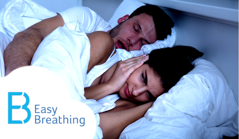 Man Snoring in bed and wife covering her ears.
